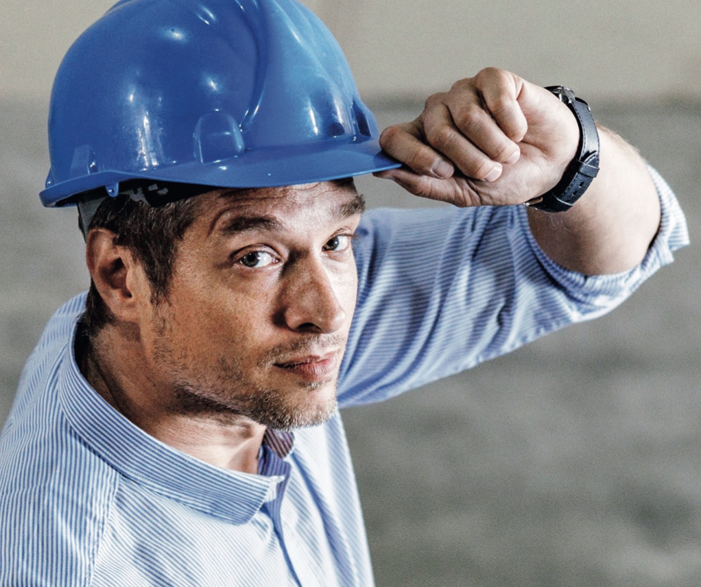 Bauleiter mit blauem Helm auf der Baustelle