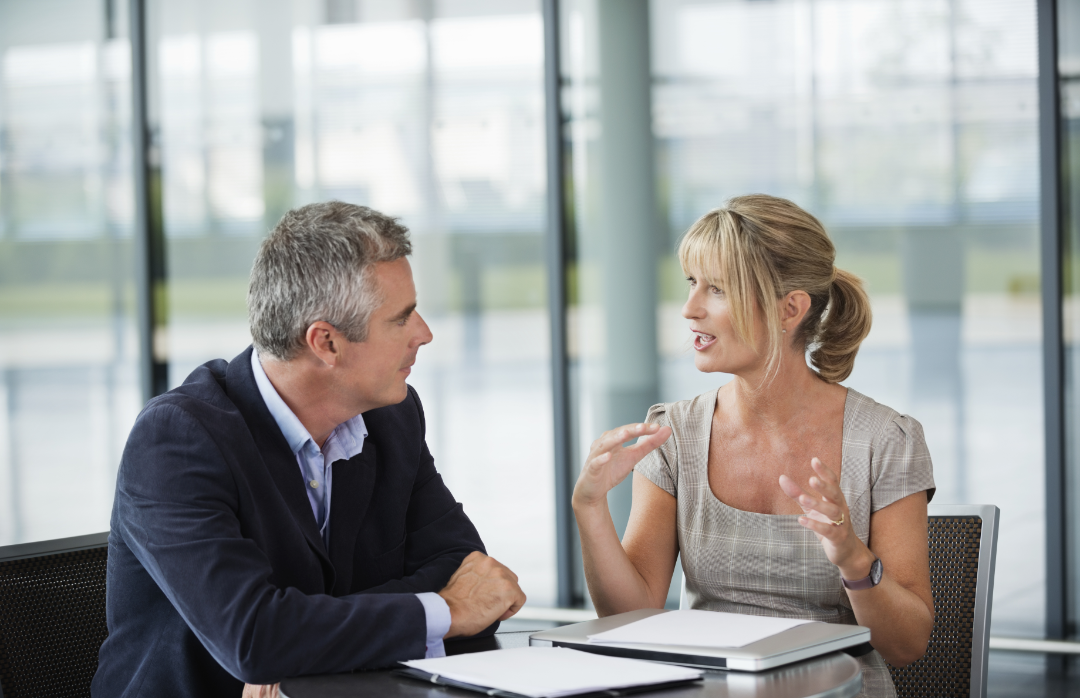 Zwei Personen unterhalten sich im beruflichen Kontext.